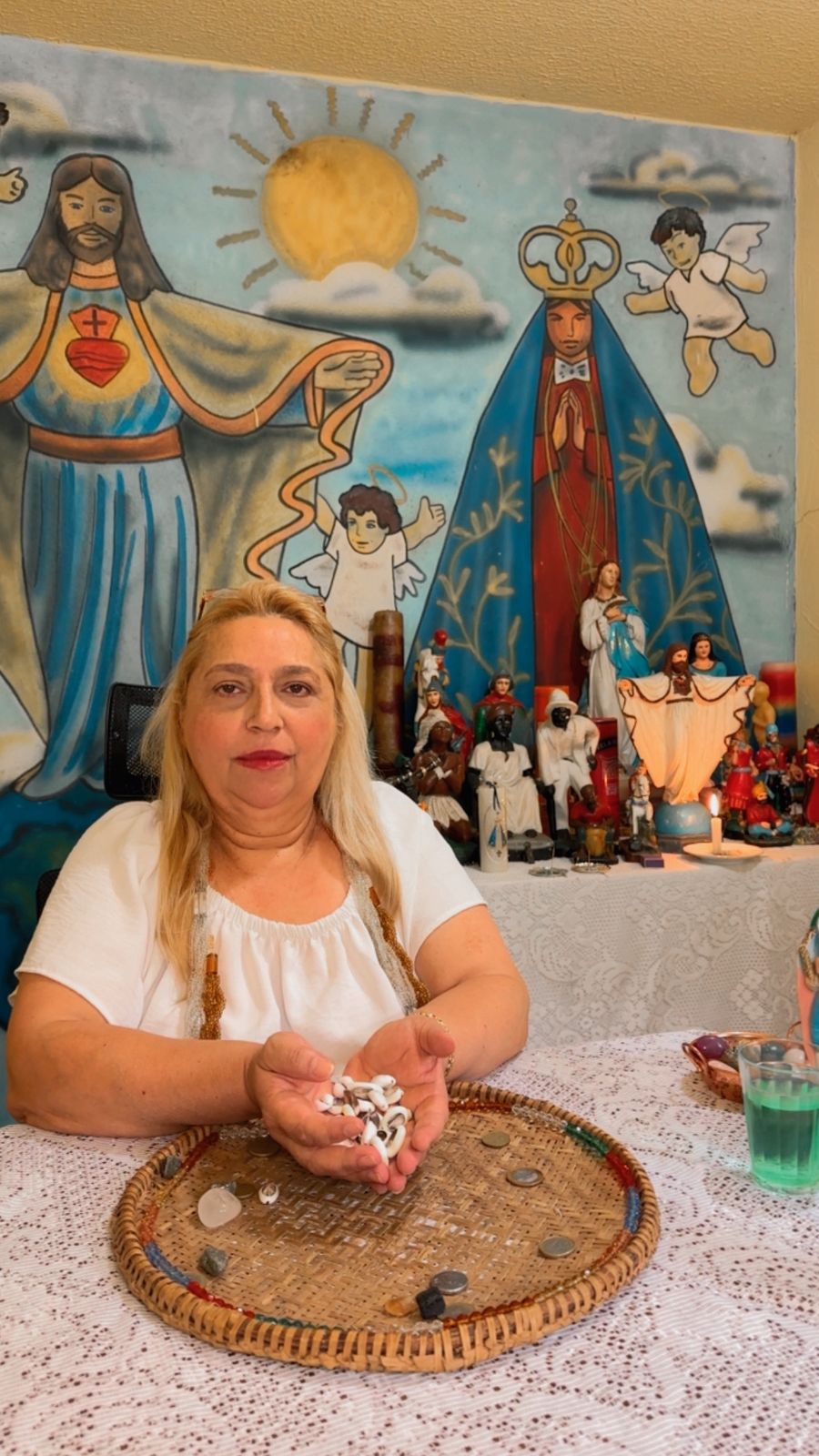 Mãe Márcia do Axé com búzios e altar espiritual
